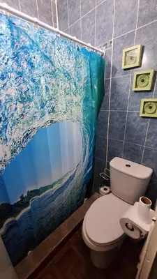 a bathroom with a toilet and a painting on the wall at Hidden House in Santa Ana