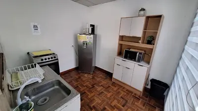 a small kitchen with a sink and a refrigerator at Hidden House in Santa Ana