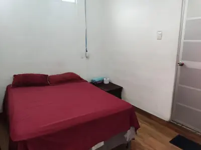 a small bedroom with a bed with a red blanket at Hostal Santa Marta in La Unión