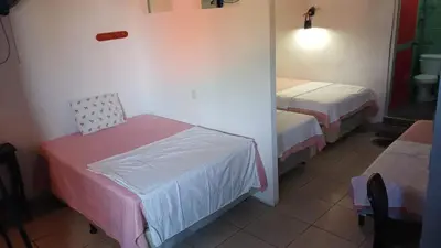 a small room with two beds and a mirror at Hostal Santa Marta in La Unión
