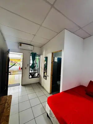 a bedroom with a red bed in a room at LA CASONA SV Hostal in La Libertad