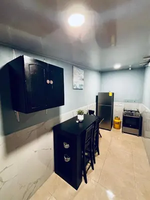 a kitchen with a black table and a refrigerator at Hostal Camila’s in Tamanique