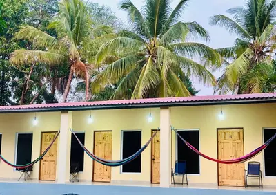 a building with hammocks in front of it at Hostal Camila’s in Tamanique