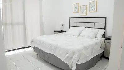 a white bedroom with a large bed and a window at House in San Miguel, Res. San Andres in San Miguel