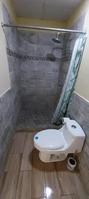 a bathroom with a shower with a toilet and a sink at Hostal San José in La Unión