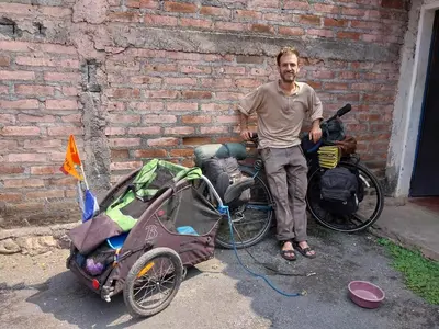 a man standing next to a bike with a cart at Hostal San José in La Unión