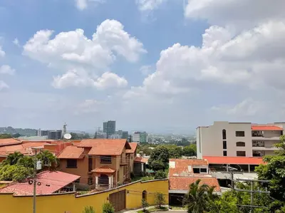 a view of a city with buildings and clouds at Encanto Urbano in San Salvador