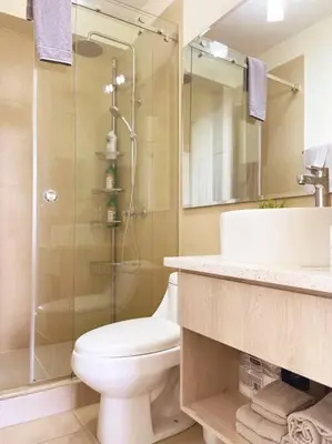 a bathroom with a toilet and a glass shower at Encanto Urbano in San Salvador