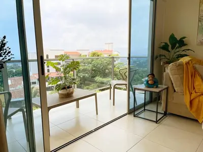 a living room with a view of a balcony at Encanto Urbano in San Salvador