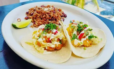 a plate of food with tacos and rice on a table at KaiBlue Hotel y Restaurante in La Libertad