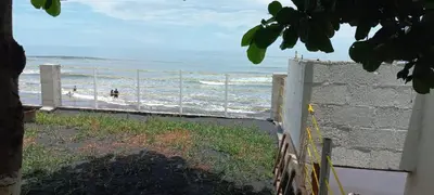 a fence on the beach with people in the water at KaiBlue Hotel y Restaurante in La Libertad