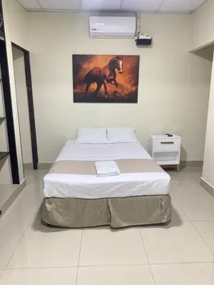 a bed in a room with a painting of a horse at Hotel La Capilla - Suites & Apartments San Benito in San Salvador