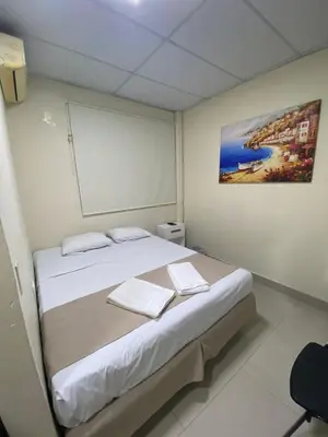 a bedroom with a large bed with a picture on the wall at Hotel La Capilla - Suites & Apartments San Benito in San Salvador
