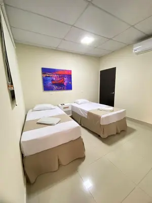 a room with two beds and a painting on the wall at Hotel La Capilla - Suites & Apartments San Benito in San Salvador