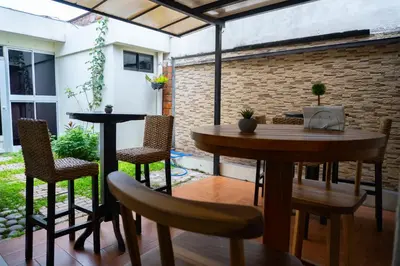 a patio with a wooden table and chairs at Hotel La Capilla - Suites & Apartments San Benito in San Salvador