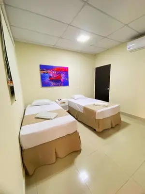 a room with two beds and a painting on the wall at Hotel La Capilla - Suites & Apartments San Benito in San Salvador