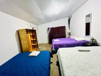 two beds in a room with purple and white at Entre tejas in Concepción de Ataco