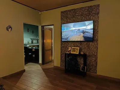 a living room with a flat screen tv on a wall at Enjoy Your Vacation at Tone'y House in Chalchuapa