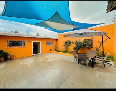 a patio with an umbrella and a table and chairs at Enjoy Your Vacation at Tone'y House in Chalchuapa