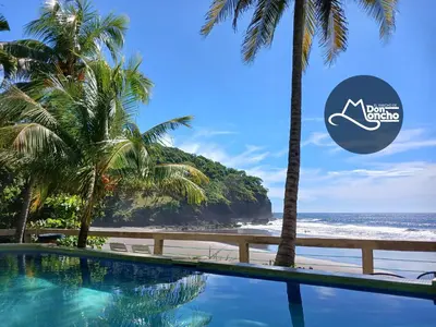 a swimming pool next to a beach with palm trees at El Patio de Don Moncho - Shalpa in Jicalapa