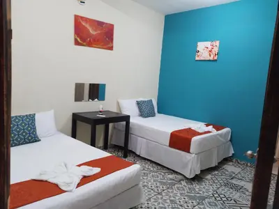 a hotel room with two beds and a table at El Patio de Don Moncho - Shalpa in Jicalapa