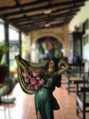 a statue of a woman holding pink roses at Casa Degraciela - Hotel Boutique in Concepción de Ataco