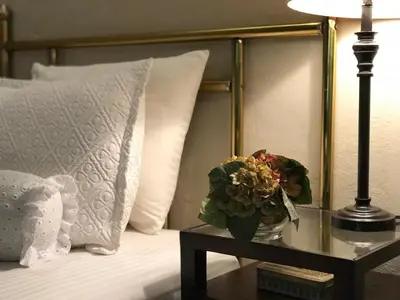 a vase of flowers on a table next to a bed at Casa Degraciela - Hotel Boutique in Concepción de Ataco