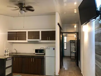 a kitchen with a white refrigerator and wooden cabinets at INGRID LOFTS in La Unión
