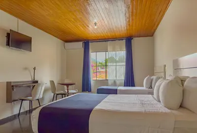 a hotel room with two beds and a window at Cardedeu Suites in San Salvador