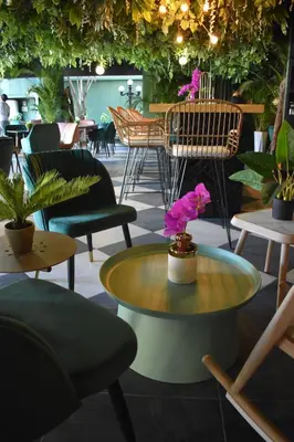 a room with chairs and a table with flowers on it at Cardedeu Suites in San Salvador