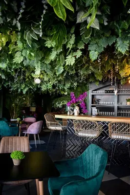 a restaurant with a green wall with plants at Cardedeu Suites in San Salvador