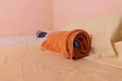 an orange towel sitting on top of a bed at Hostal Delmy in Suchitoto