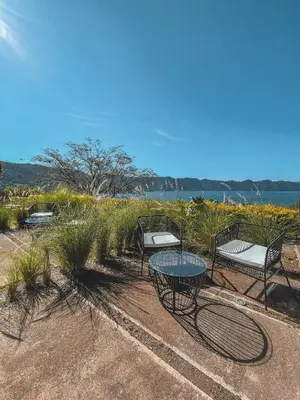 a group of chairs and a table in a field at Cardedeu Hotel Lago de Coatepeque in El Congo