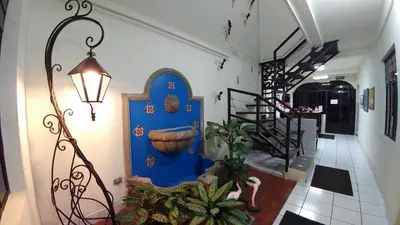 a hallway with a blue wall in a house at Hotel Armonía Hostal in San Salvador