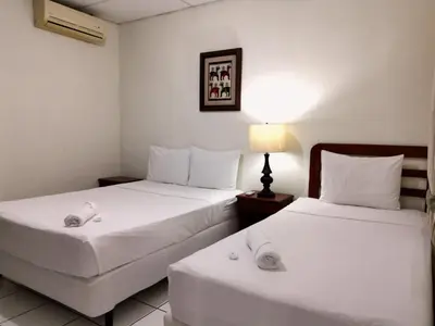 a hotel room with two beds and a lamp at Hotel Armonía Hostal in San Salvador