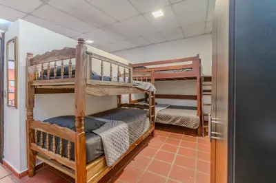 a room with two bunk beds and a refrigerator at San Diego Beach House, near La Lib and Surf City in La Libertad