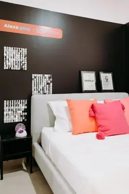 a bedroom with a white bed with orange and pink pillows at ¡Sivar Sound! Music Design! in San Salvador