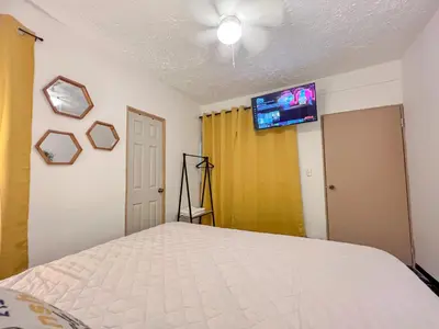 a bedroom with a bed and a tv on the wall at Casa Serena B&B in Nueva San Salvador