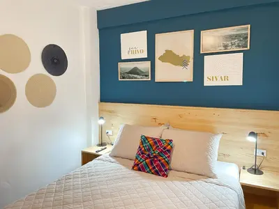 a bedroom with a bed with a blue wall at Casa Serena B&B in Nueva San Salvador