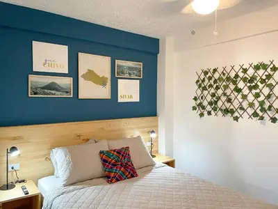 a bedroom with a blue accent wall and a bed at Casa Serena B&B in Nueva San Salvador