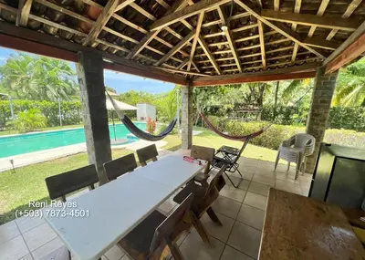 a patio with a table and chairs and a hammock at Las Veraneras Villa - Pet Friendly in Acajutla