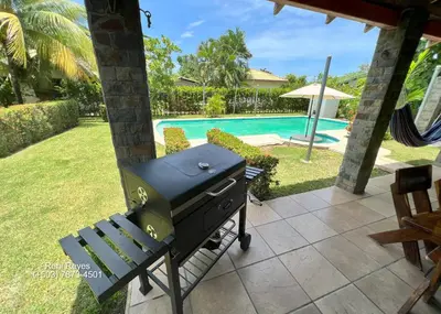 a barbecue grill on a patio next to a pool at Las Veraneras Villa - Pet Friendly in Acajutla