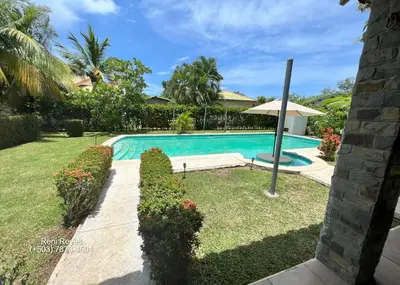a swimming pool in a yard with an umbrella at Las Veraneras Villa - Pet Friendly in Acajutla