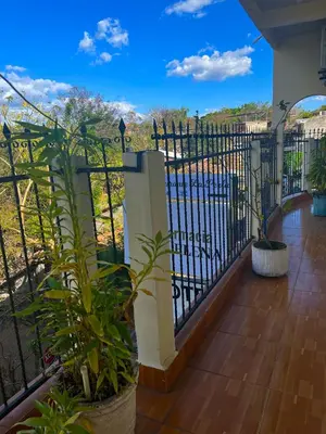 a wrought iron fence with a view of a pool at Hotel y Restaurante La Perla, Cacaopera, Morazan, El Salvador in Cacaopera