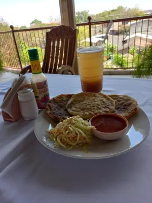a plate of food with a drink and a plate of food at Hotel y Restaurante La Perla, Cacaopera, Morazan, El Salvador in Cacaopera