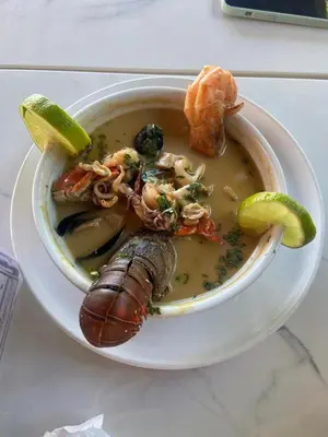 a bowl of soup with seafood and vegetables on a table at The Views Resort in El Zonte