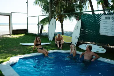 a group of people sitting in a pool with surfboards at Bella Vista Hotel Boutique in San Miguel