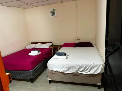 two beds in a small room with red and white sheets at Casa isabel in Santa Ana
