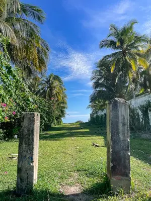 two stone posts in a field with palm trees at Casa De Playa El Encanto in El Porvenir