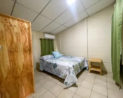 a small bedroom with a bed and a table at Casa De Playa El Encanto in El Porvenir